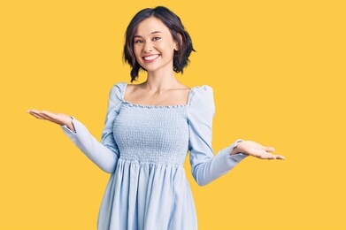 young beautiful girl wearing casual clothes smiling showing both hands open palms, presenting and advertising comparison and balance 