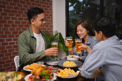 group of asian friends are celebrating the festival, they clink glasses beer.