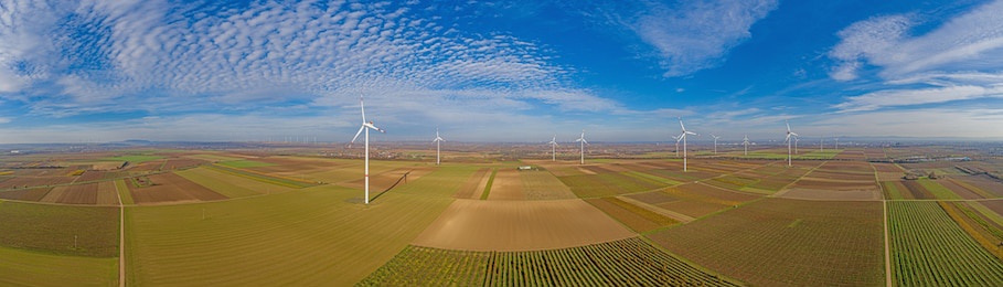 panoramic aerial photo of a wind farm in germany during the day with blue sky and light clouds