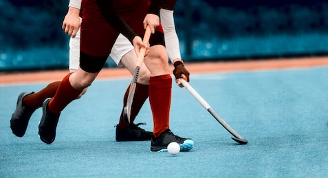 two man battle for control of ball during field hockey game. sport team concept. vintage color filter