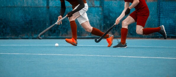 two man battle for control of ball during field hockey game. sport team concept. vintage color filter