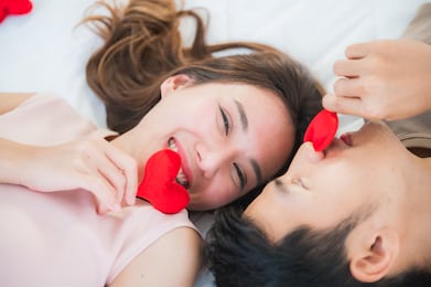 happy young couple in bed with red hearts