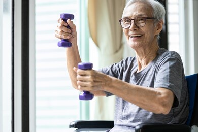 strong asian senior woman working out with heavy dumbbells,lifting dumbbell weights for strength training,fitness elderly people doing exercise while sit in wheelchair,health care,healthy lifestyle
