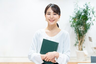 young asian woman holding a book.