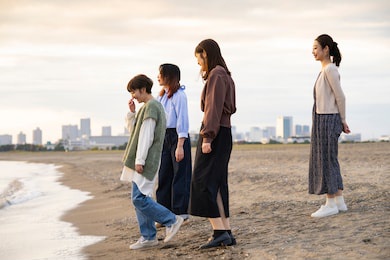 4 young women playing by the sea in the dusk