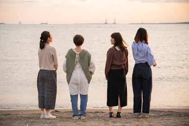 4 young women playing by the sea in the dusk