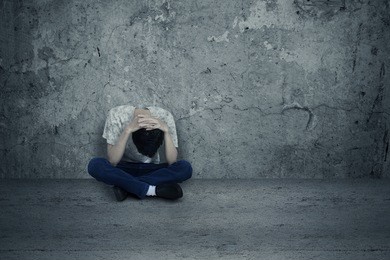 young man hopeless sitting alone on the floor