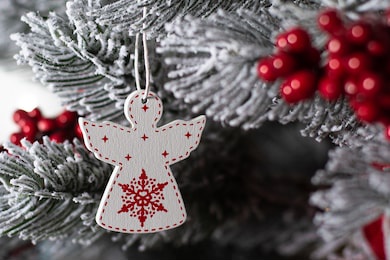 white christmas angel on a tree. wooden angel on the christmas tree. macro photo.
