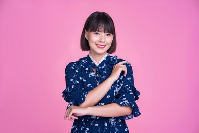 asian attractive cute short hair woman happy smiling arms crossed confident independent strong mother businesswoman wearing casual dress pink isolated background in studio portrait looking into camera