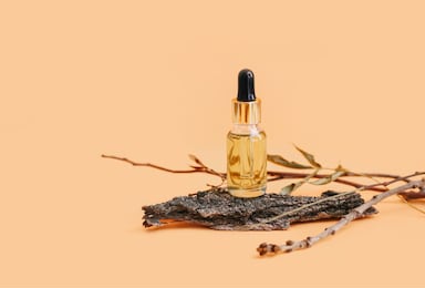 cosmetic skin care product on tree bark. natural cosmetics concept. light warm peach colored background