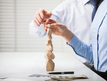 business people building wooden tower (japanese game tumi-ishi), illustrating concept of business success, cooperation, achievement and self-control