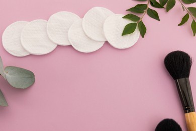 makeup brushes, cotton pads and plants on pink background. beauty make up freshness copy space concept.