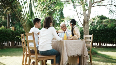happy asian family having festive dinner, multi generation family enjoying meal together. people having outdoor party eating food at backyard home, lifestyle family concept party at summer garden.
