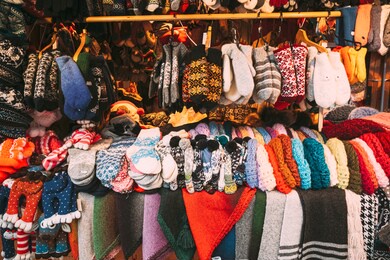 traditional christmas winter market trading houses with warm clothes, wear and hats. colorful knitted traditional european warm clothes - mittens and scarfs. xmas souvenir from europe