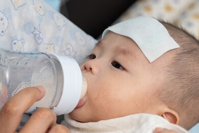 mother on feeding 4 month baby boy milk during baby having high fever