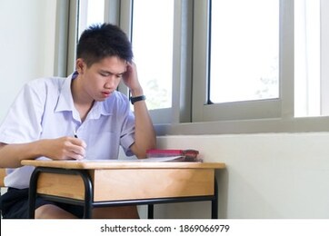 concentration in exam in school of smart young asian student thinking serious in test final in learning at high school classroom with  thai white shirt uniform