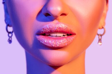 close up view of beautiful woman lips in colourful bright light.