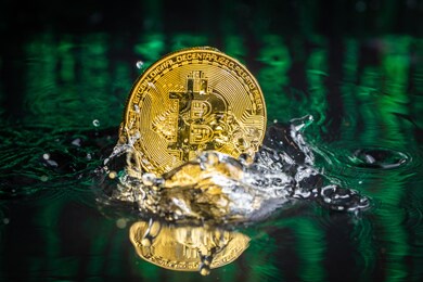 gold bitcoin coin falling to water. bitcoin and water splash.