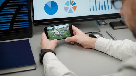 manager at work, browsing video on the smartphone. sitting in the office, you can distract yourself and watch the video over the internet.