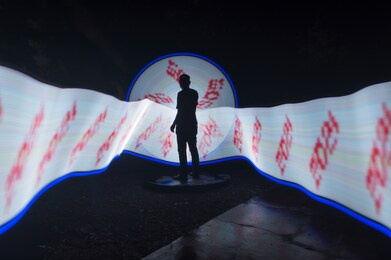 one person standing alone against beautiful white and blue circle light painting as the backdrop