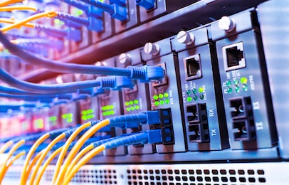 fiber optical cables connected to an optic ports and network cables connected to ethernet ports