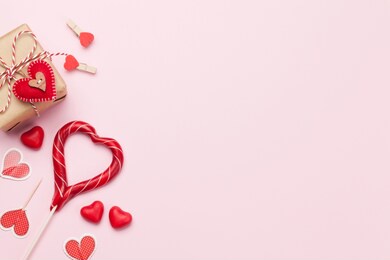 valentines day greeting card with gift box and candy over pink background with copy space for your greetings. top view flat lay