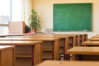 classroom with desks and a green blackboard