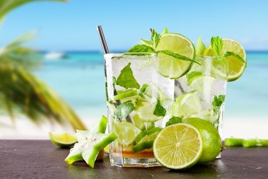 mojito drink on wood with blur beach background