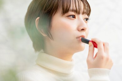 asian young woman applying lipstick