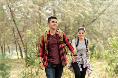 asian couples, men holding hands, women walking happily while traveling in the forest