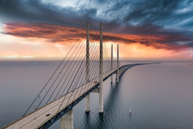 the bridge between denmark and sweden, oresundsbron. aerial view of the bridge during cloudy stormy weather with lightning.