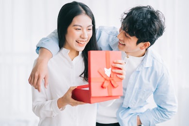 asian girl feels happy and surprised to receive gifts from her boyfriend on valentine's day

