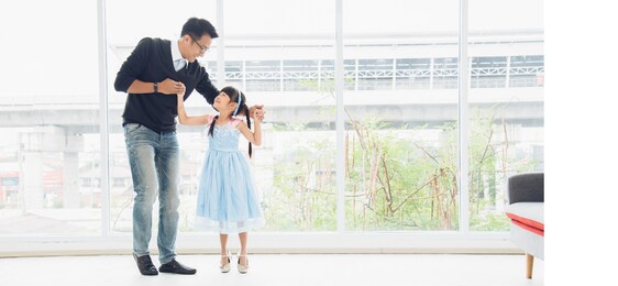 father is teaching his little daughter to dance in the halls of the house. happy holidays, family relationships.