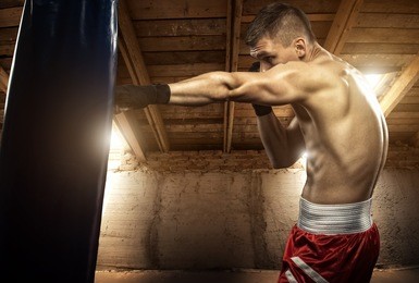 young man boxing, exercise in the attic
