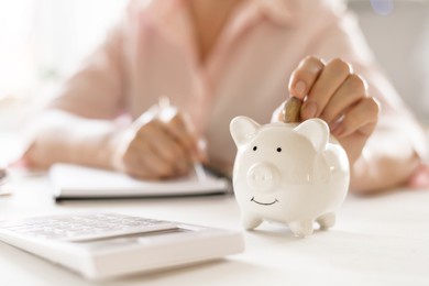 old women's hand put money coins in a piggy bank, the concept of retirement.