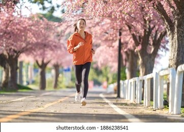 asian woman exercise in the morning she is running at sakura park.