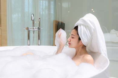 happy asian woman bathes with white foam in a bathtub fun emotions.