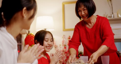 happy chinese family eating dinner for chinese new year celebrations together at home.