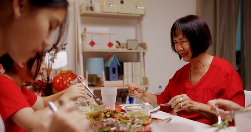 happy chinese family eating dinner for chinese new year celebrations together at home.