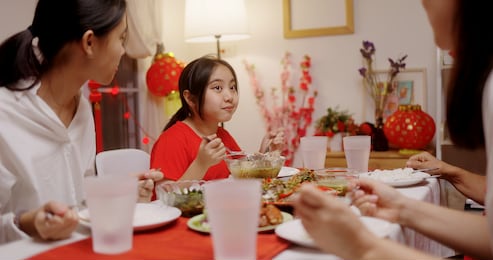 happy chinese family eating dinner for chinese new year celebrations together at home.