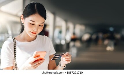 business people shopping via online application media concept. happy smile young adult asian woman consumer using creadit card and smartphone. city on day background with copy space.