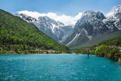 white water river waterfall at the cliffs and brooks at the foot of jade dragon snow mountain, lijiang, yunnan china.