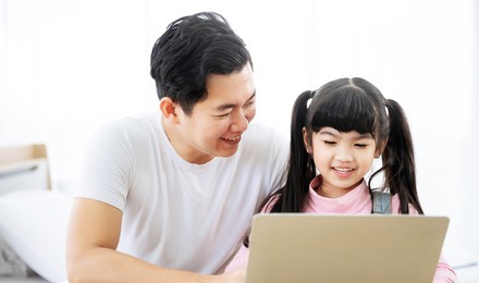 father and daughter learning education study online class. kid girl and dad using computer laptop at home