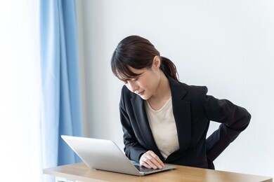 asian businesswoman with back pain working from home 