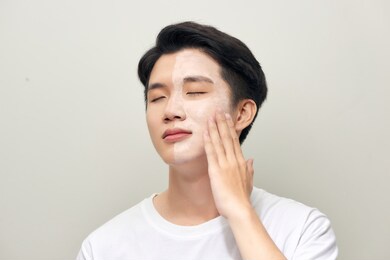 young man with clay mask on face 