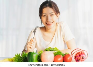 young woman is eating green vegetables for weight loss
