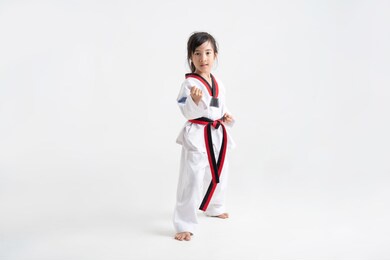 asian kid taekwondo in white studio 
