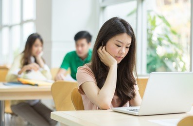 asian student studying in the library.