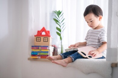 portrait cute asian baby boy reading a book,baby early education,child development concept.