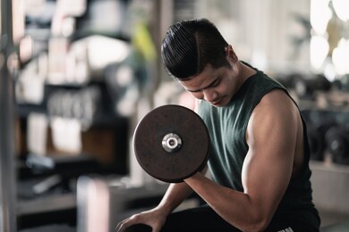 close up of hand man using dumbbell exercise at gym, sport concept